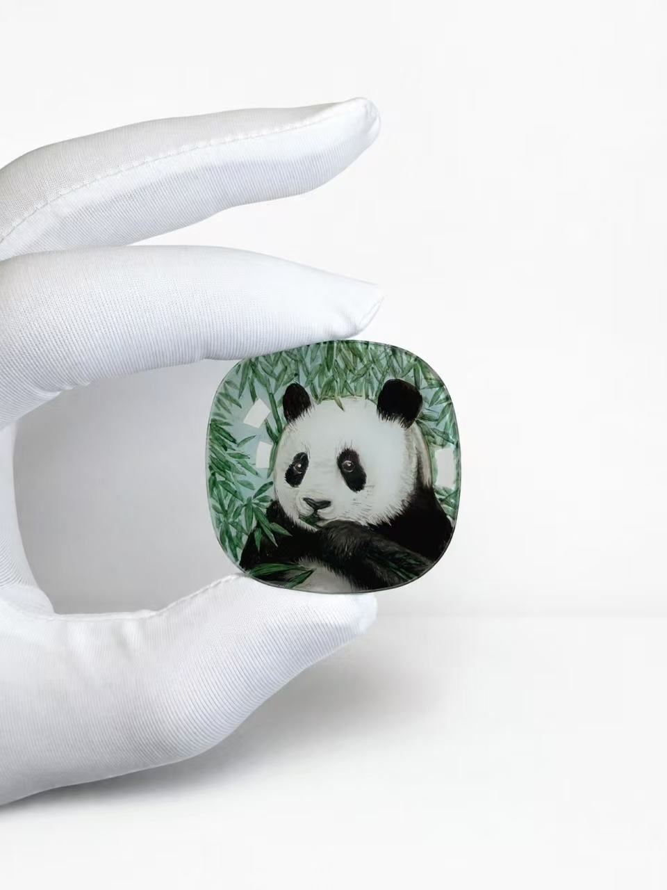 Manman Panda inner-painted sapphire crystal held in a gloved hand